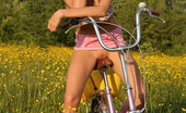 Met Art Mango A Calesma by Vlad Kleverov 45286 Fun, carefree and refreshingly cute, Mango exudes a pretty girl-next-door in her floral corset, skimpy pink skirt, and embellished sandals as she frolic on the grassy prairie with her bicycle.

