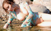 Amour Angels Katya SEA 106074 Astonishing bold angel is demonstrating her appetizing boobs through the blue blouse lying in the river.