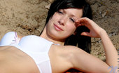 Nubiles Holly 248578 Holly In A Sexy White Bra Crouches On A Sandy Beach Check Out Her Cleavage
