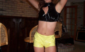 Shiny Knickers 551815 A Cute Curly Girl Posing In Her Yellow PCV Shorts Shiny Knickers
